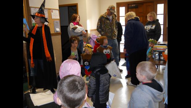 Karie Cooley (witch) reads a Halloween story to the daycare kids while they assemble.